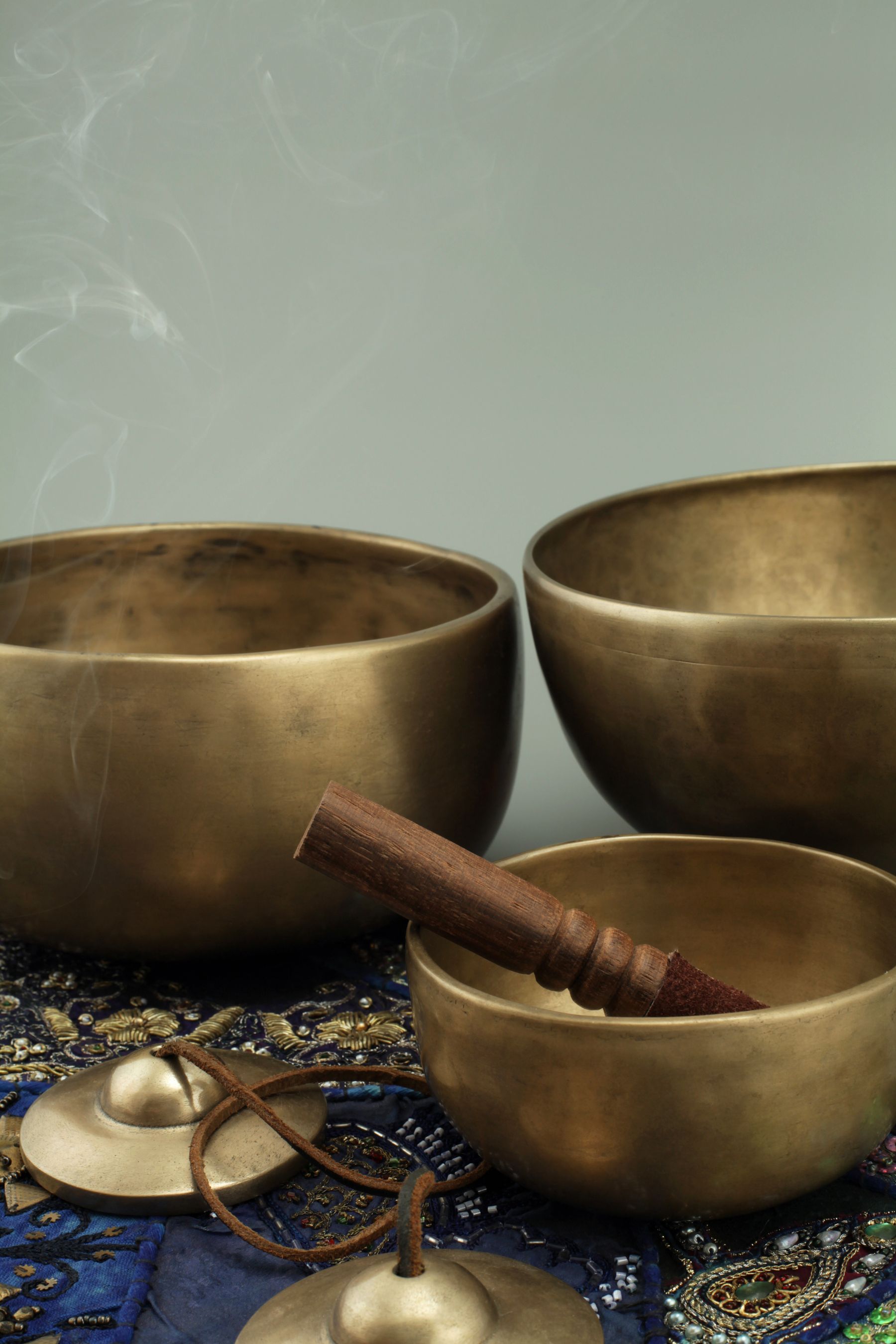 Hand-forged singing bowl, copper bell and curling incense smoke